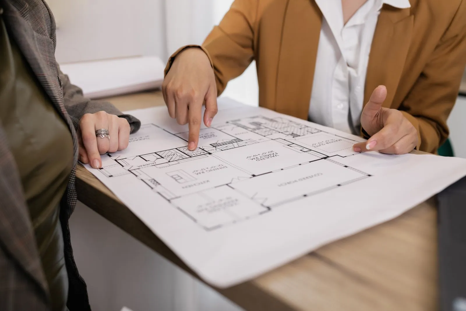 Deux personnes pointant un plan de maison